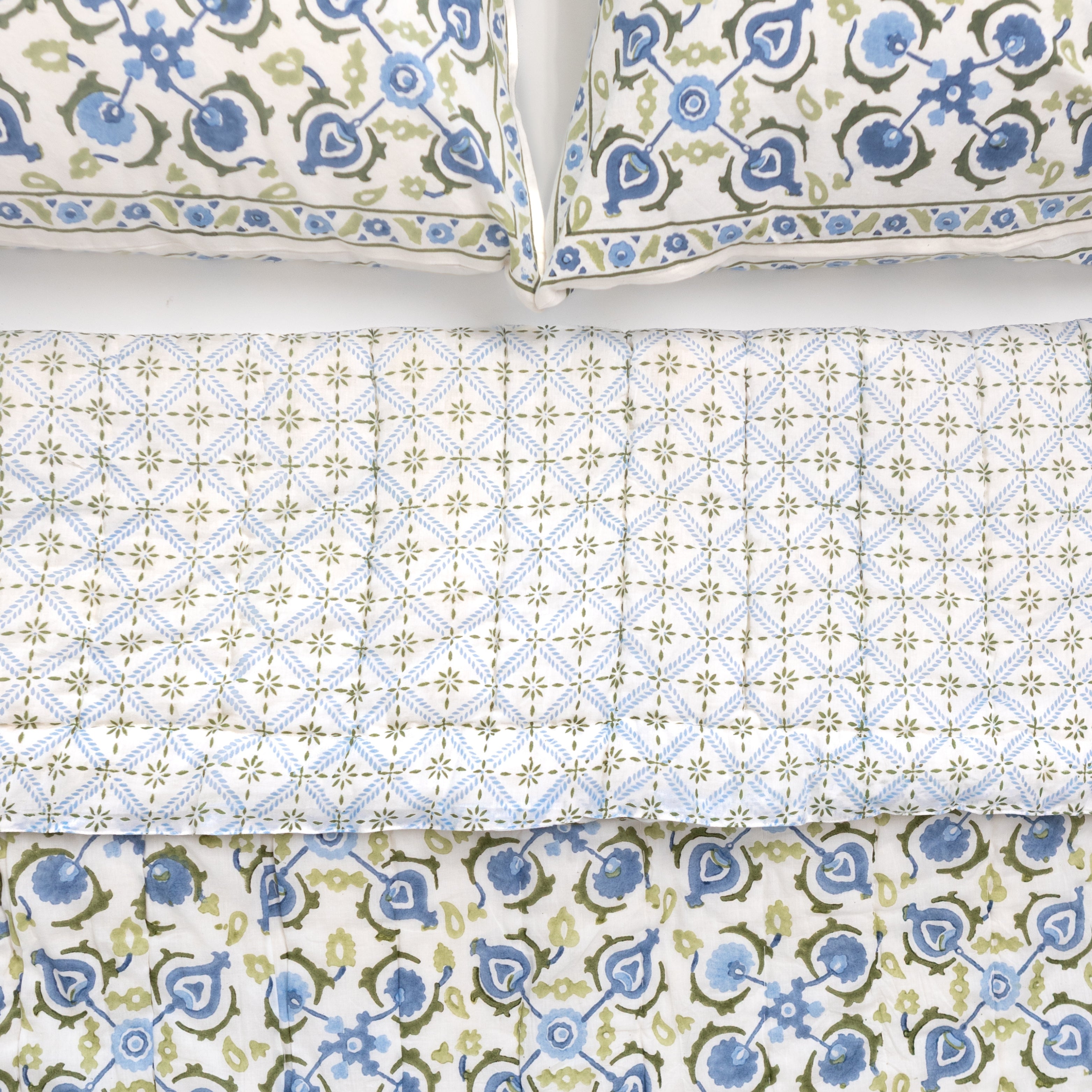 Set of patterned bed sheets and pillowcases on a white background