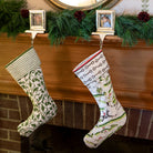 Two stockings hanging on a mantle with garland