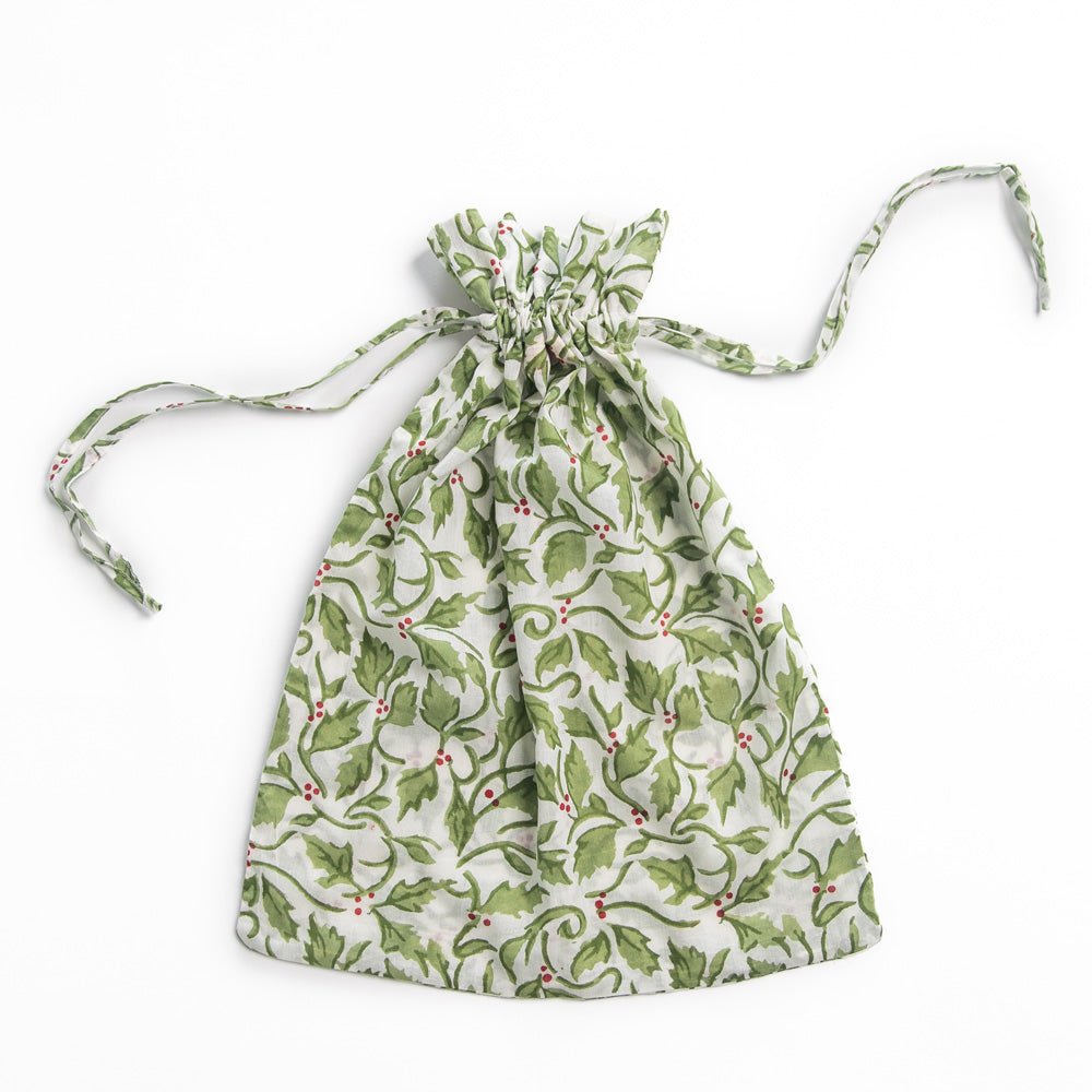 A green and red holly berry patterned drawstring bag.