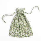 A green and red holly berry patterned drawstring bag.