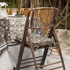 Rustic wooden chair with patterned cushion on a table with decorative tablecloth