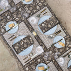 Decorative table setting with patterned tablecloth, plates, and cutlery on a textured surface.