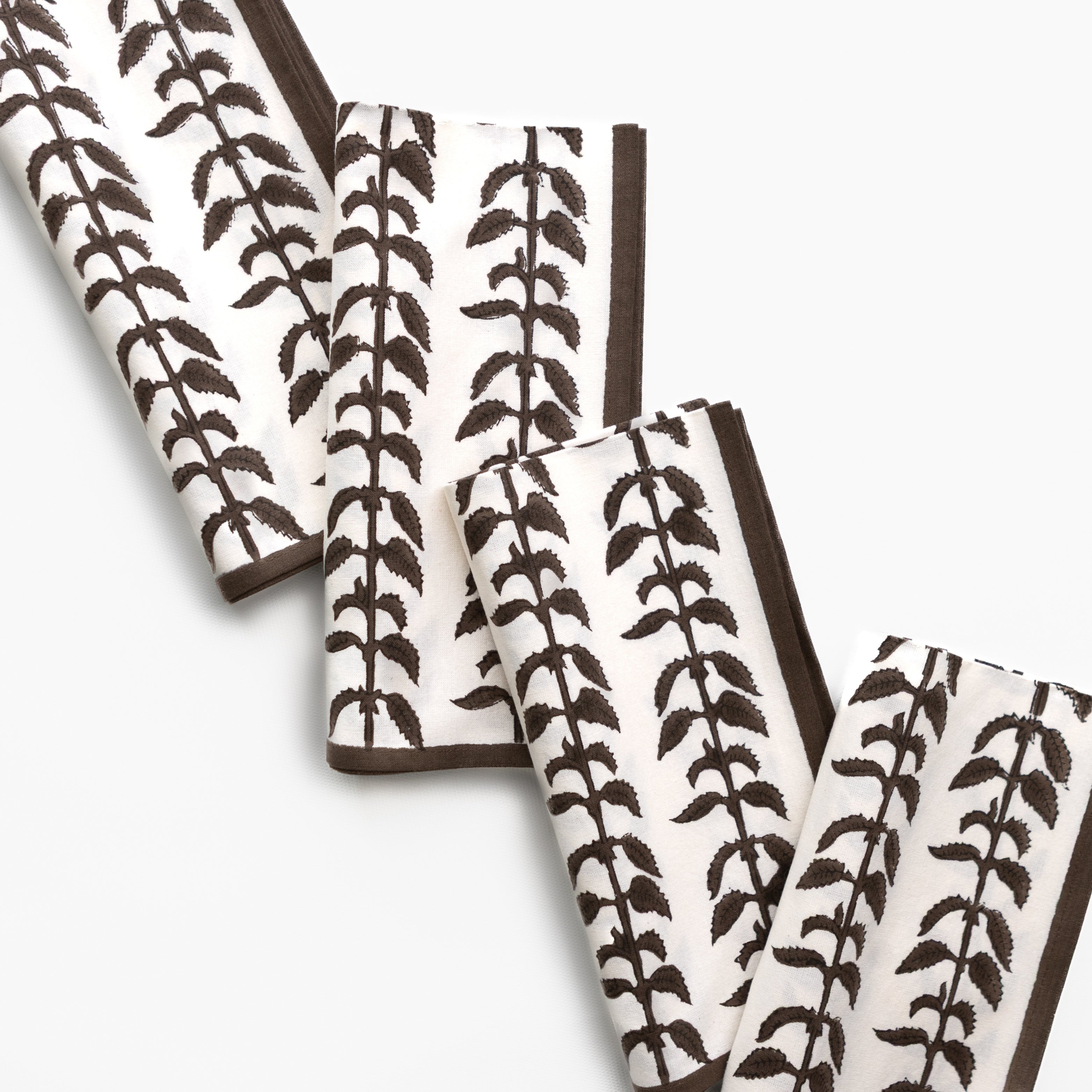 Set of folded napkins with leaf pattern on a white background