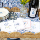 Cocktail napkins with luck charms designs in a woven scalloped tray with a bottle of wine