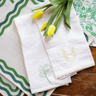 White linen kitchen tea towels embroidered with green 4 leaf clover and lucky horseshoe with scalloped border