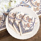 Set of patterned napkins on a white plate with a decorative background