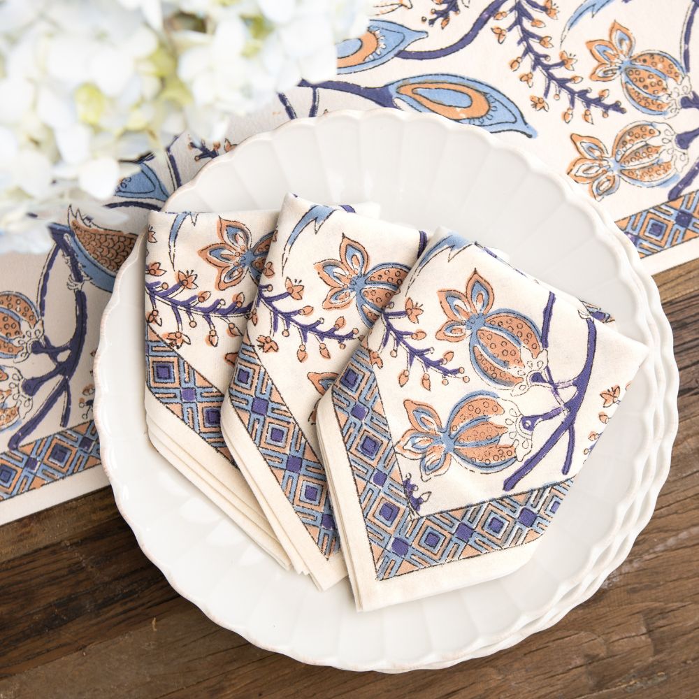 Set of patterned napkins on a white plate with a decorative background