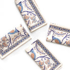 Set of decorative napkins with blue and orange patterns on a white surface
