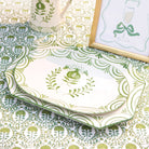Green and white patterned platters on a matching tablecloth with a framed picture.