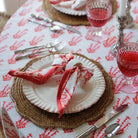A folded Sagar red and white napkin with a hand block-printed design