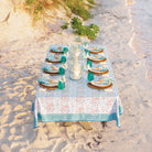 Teal & coral hand block printed cotton tablecloth set on a beach