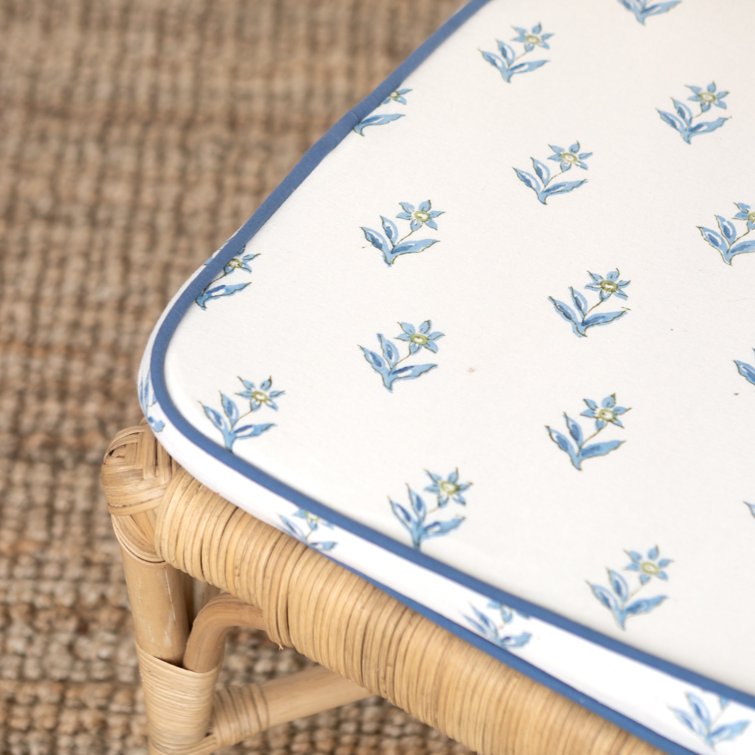 Floral-patterned cushion on a wicker chair with a woven background