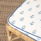 Floral-patterned cushion on a wicker chair with a woven background