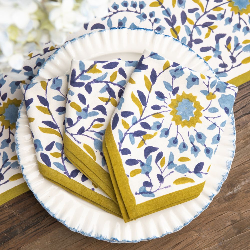 Set of floral-patterned paper plates and napkins on a wooden surface