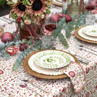 Decorative table setting with floral tablecloth, sunflowers, and pomegranates.