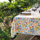 Teal and yellow tablecloth set for dinner in a garden