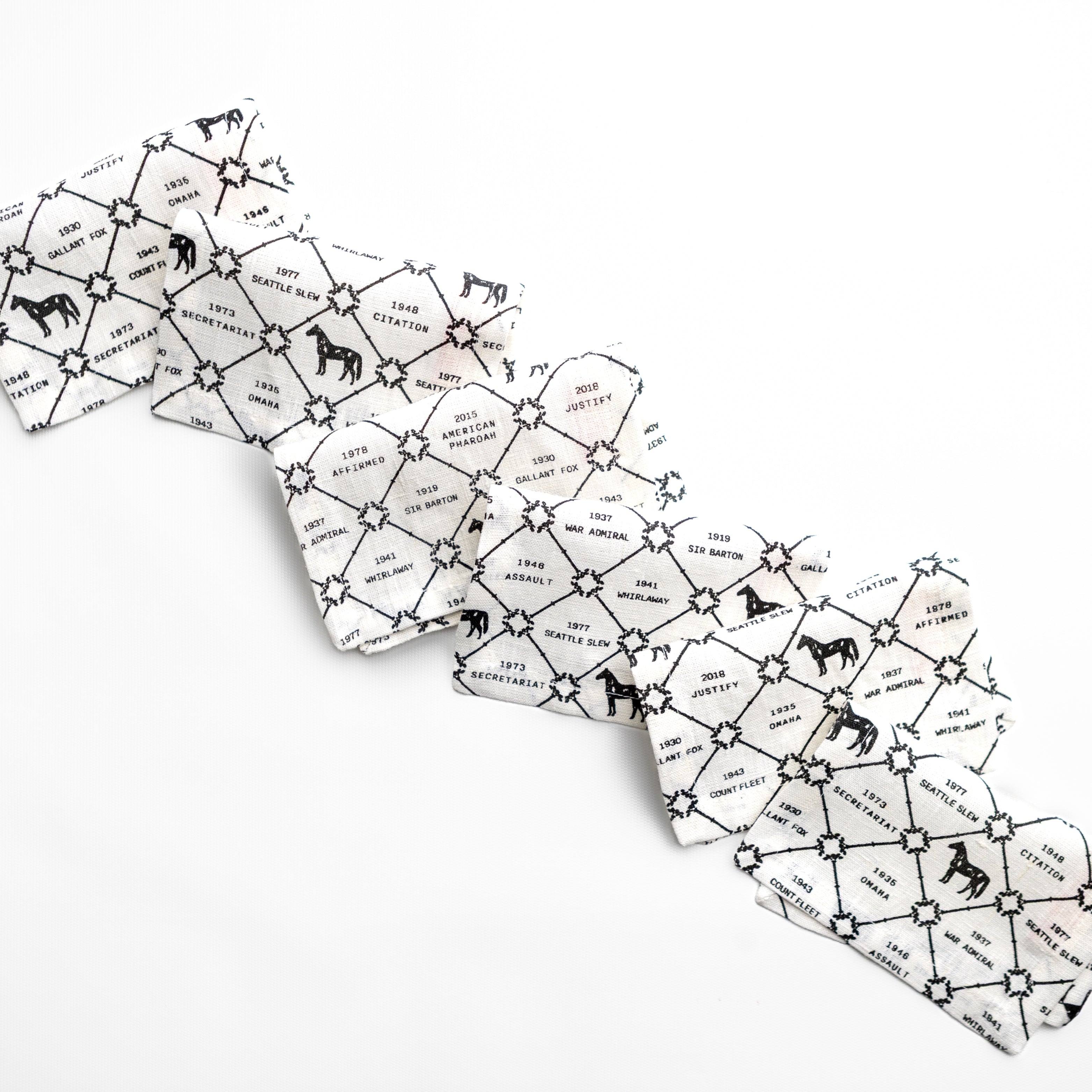 Arrangement of black and white napkins with horse patterns and text on a white background