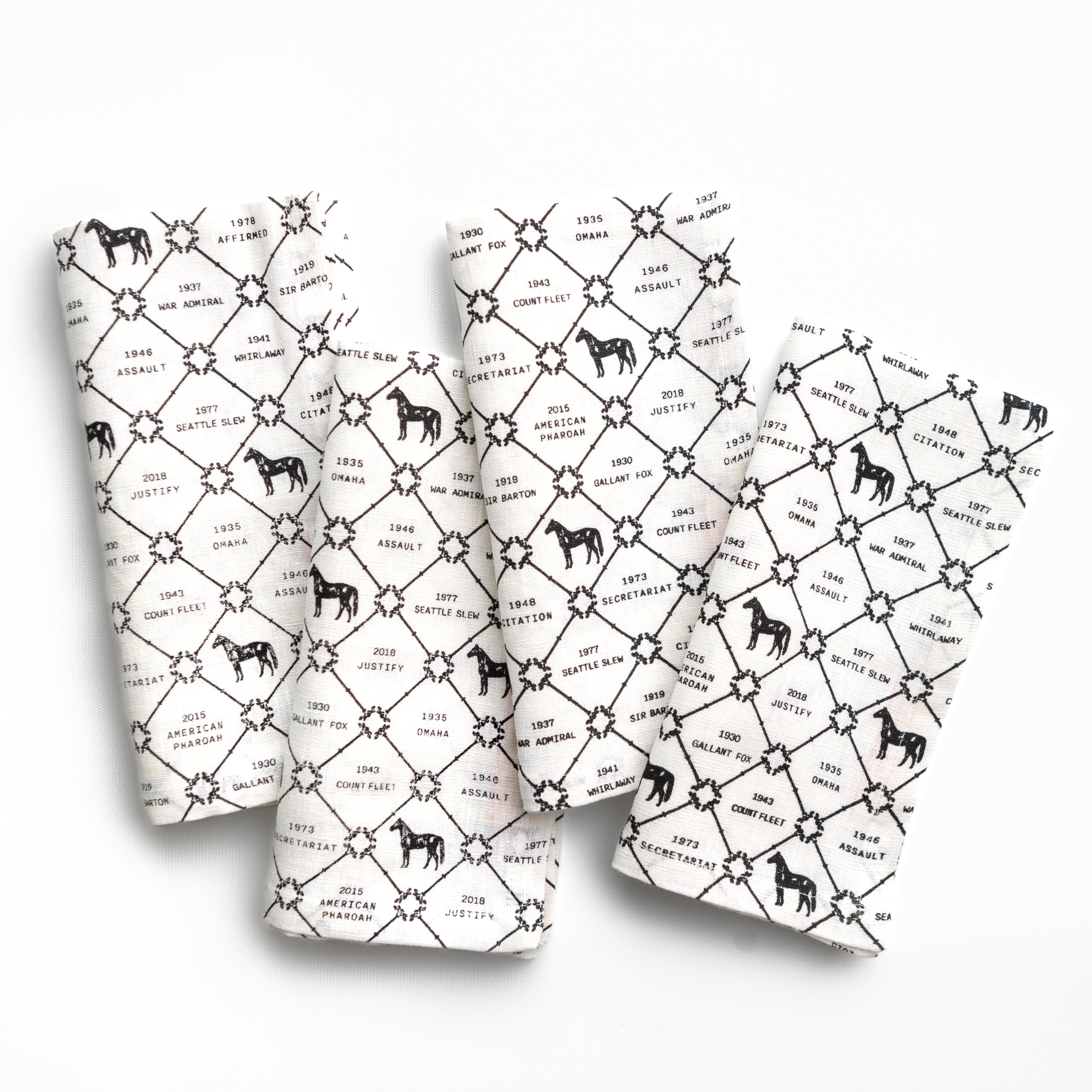 Four white napkins with black horse pattern and text on a white background