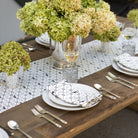 Elegant table setting with green hydrangeas, glassware, and cutlery on a wooden table.