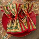 A set of 4 pinecone motif napkins tied with red ribbon