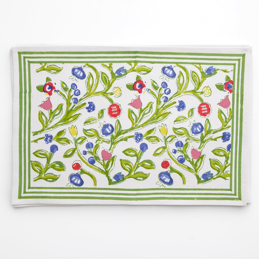 A set of four placemats with a floral pattern in shades of yellow, blue, and red