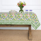 A colorful floral tablecloth with yellow, blue, and red flowers displayed on a table.