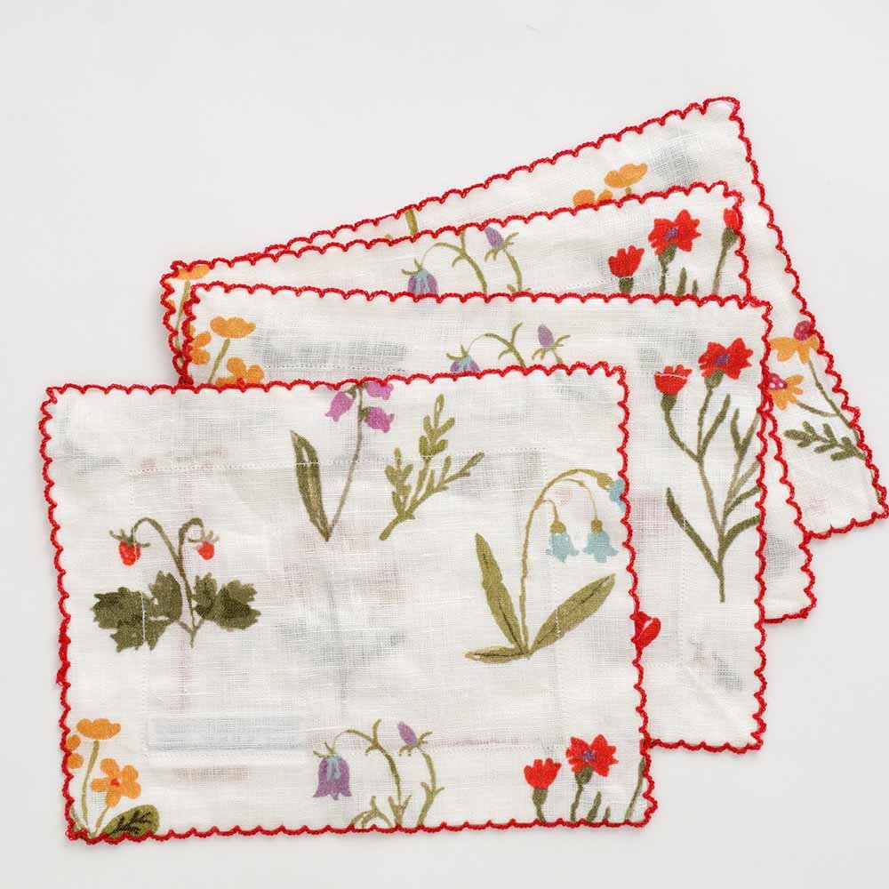Floral napkin set with red scalloped stitch.