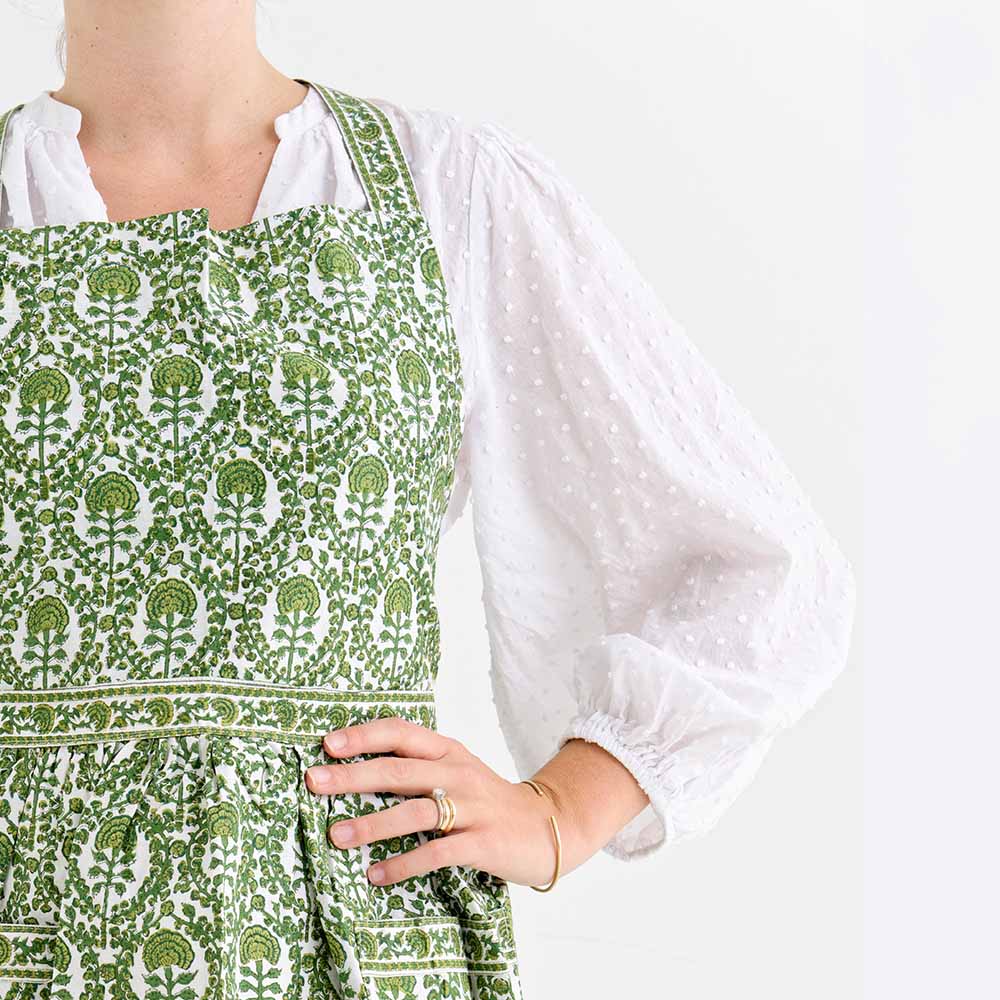Caroline Green apron consisting of intricate green and white details.