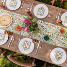 Close up of Emma table runner on dinner table decorated with basket and green centerpiece. 