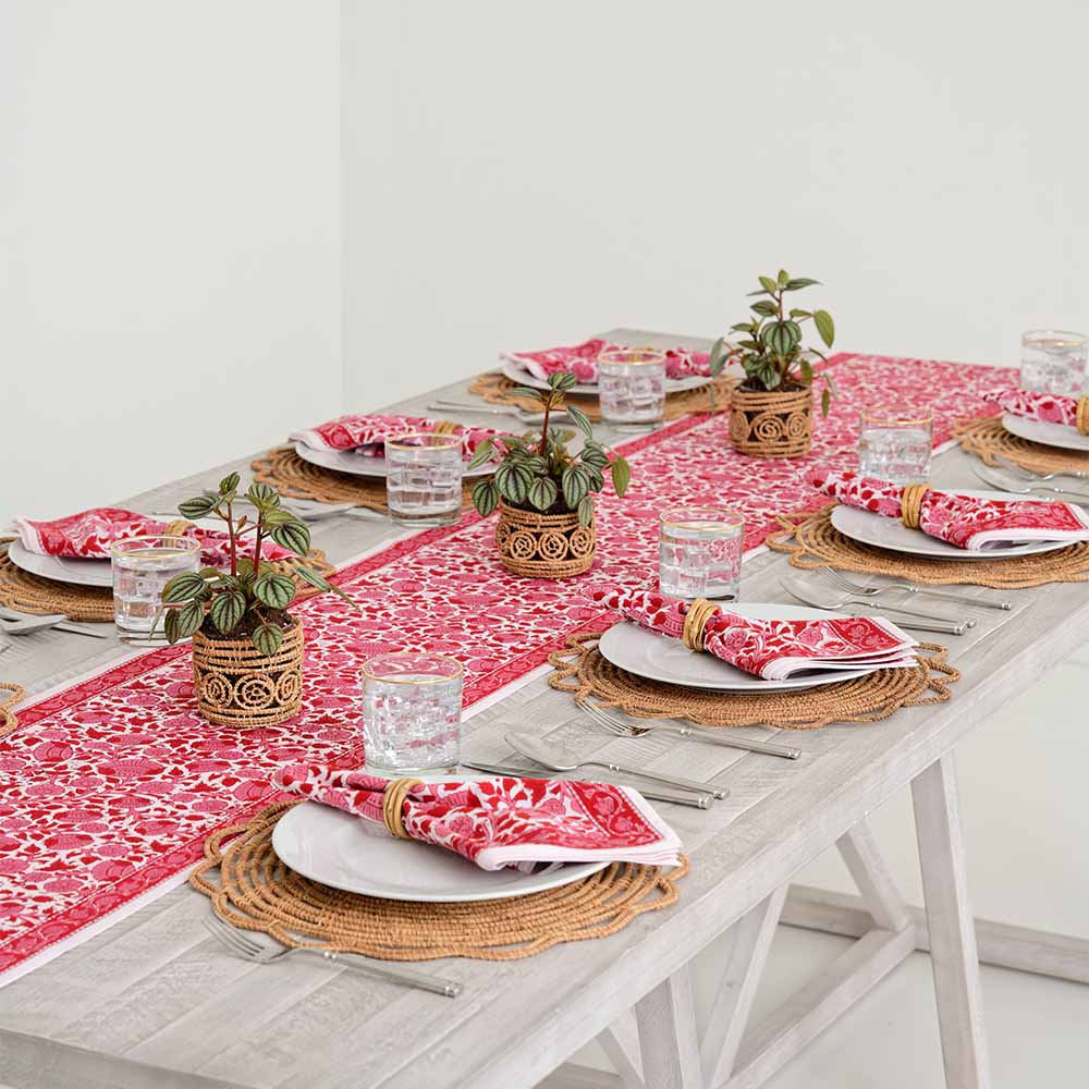 Crimson Blossom table runner paired with matching napkins on a dinner table. 