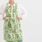Pom Bells Green apron with ties behind the neck and around the waist.