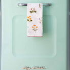 Tea towel hanging on a turquoise blue refrigerator.