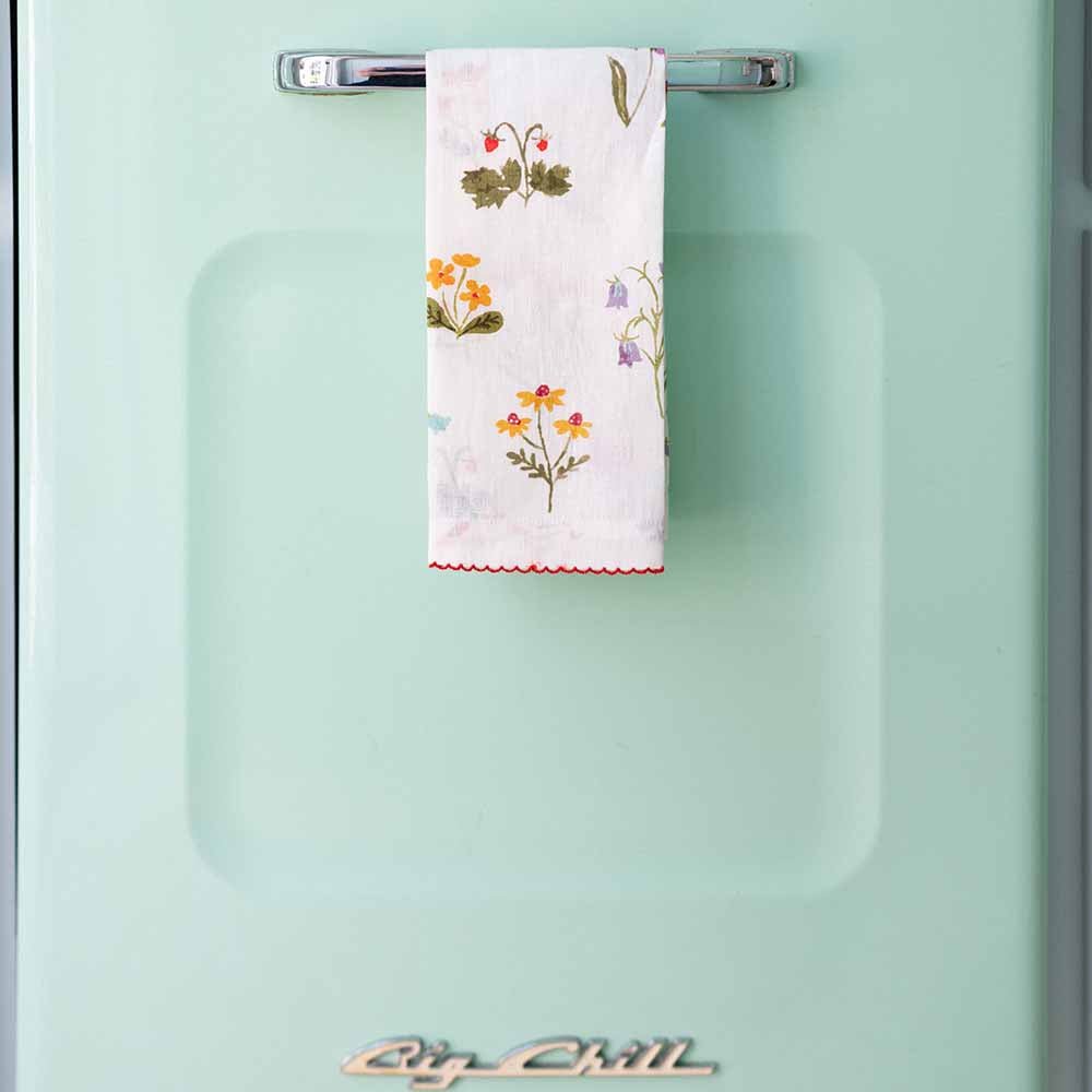 Tea towel hanging on a turquoise blue refrigerator. 