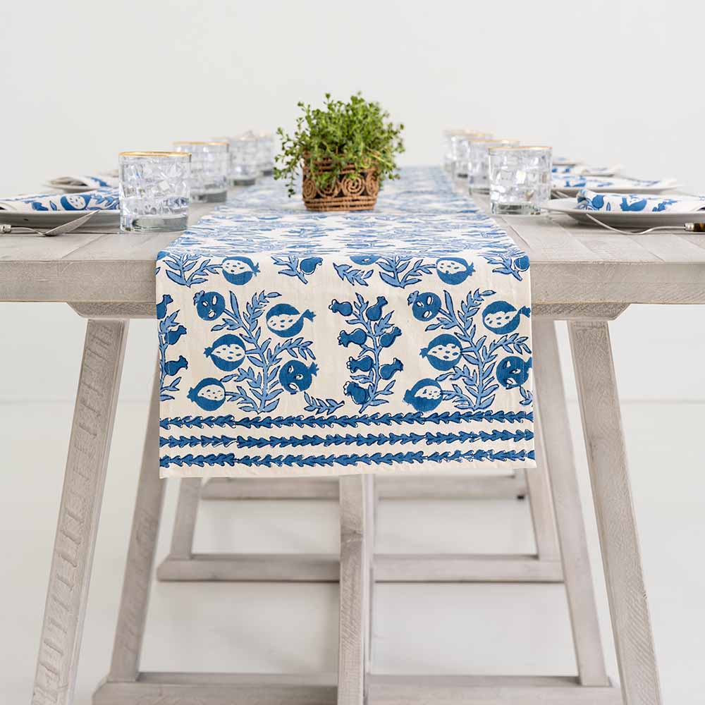 Blue and white pattern table runner decorating middle of dinner table.