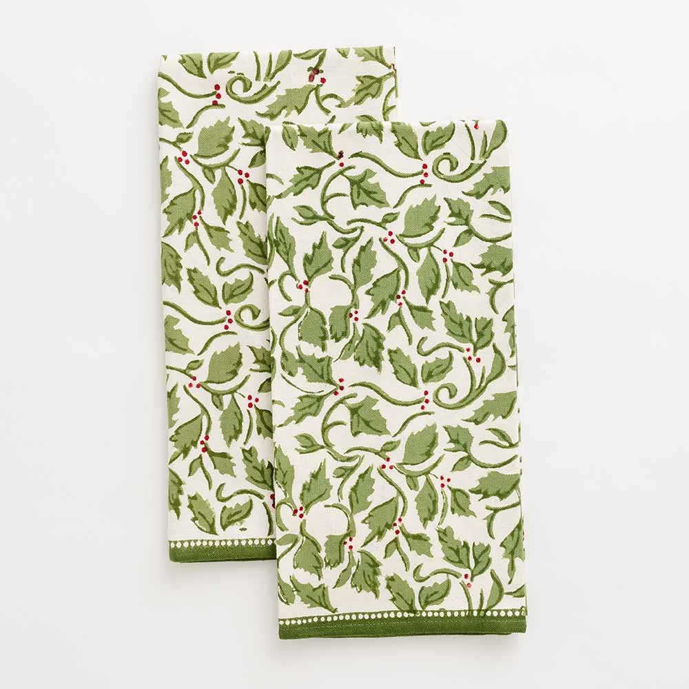 A set of two green and white kitchen towels with a printed pattern of holly and berries.