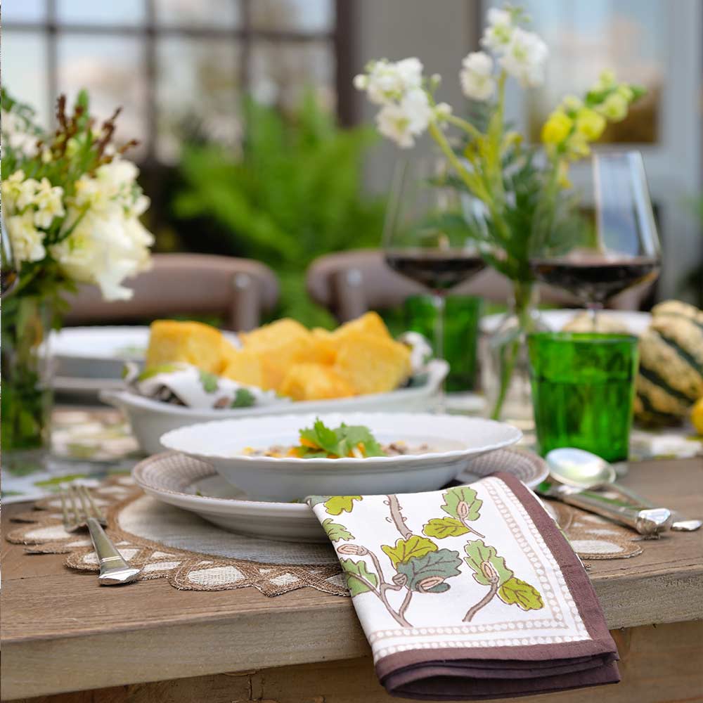 Dinner table with napkin and green glasses.