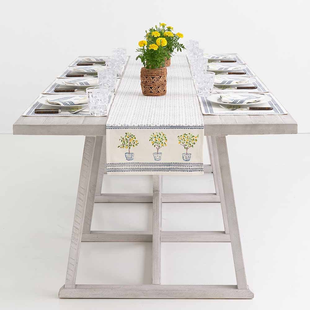 Lemon Topiary table runner decorating middle of dinner table with flowers.