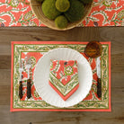 Harvest Pinecone orange & green floral napkin on white plate with matching placemat and table runner