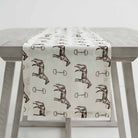 Horse and Snaffle Linen Table Runner draped over the side of a table.