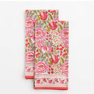 A set of two folded tea towels with a floral pattern in shades of pink and green.