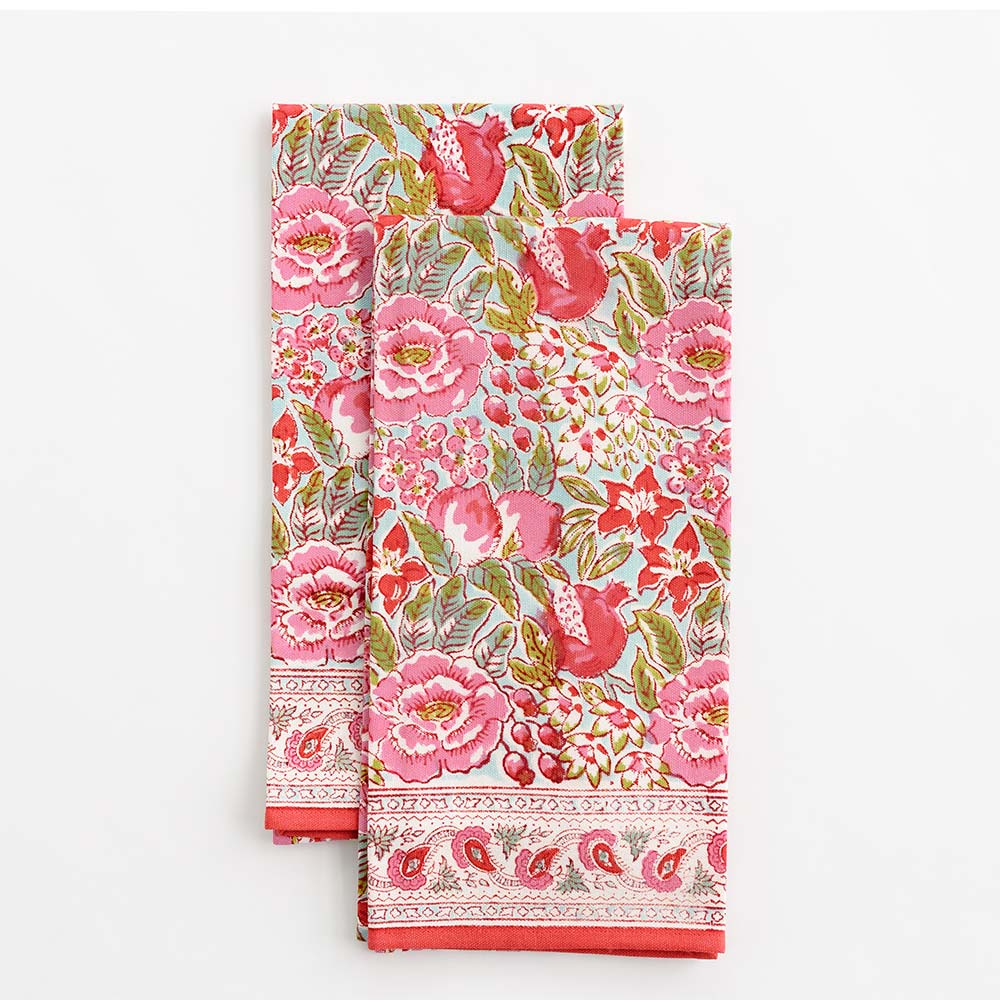 A set of two folded tea towels with a floral pattern in shades of pink and green.