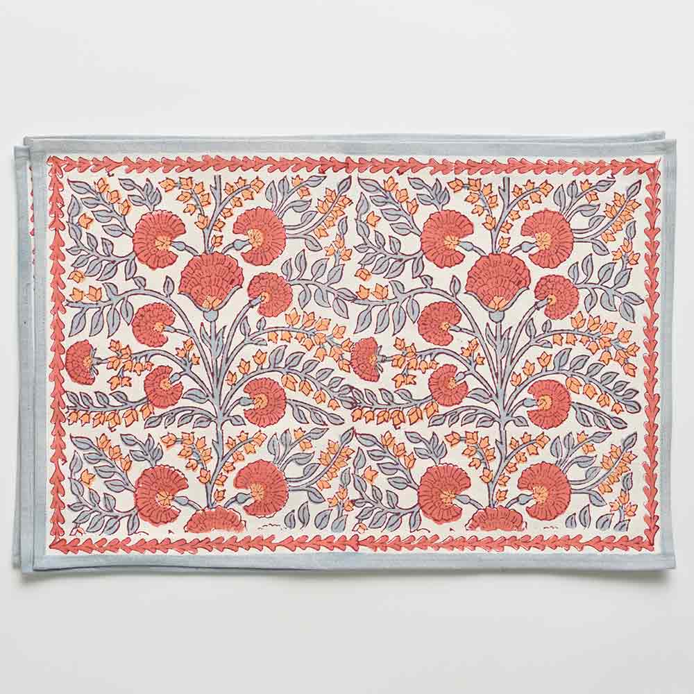 A rectangular placemat with a floral pattern featuring periwinkle vines and warm orange blooms.