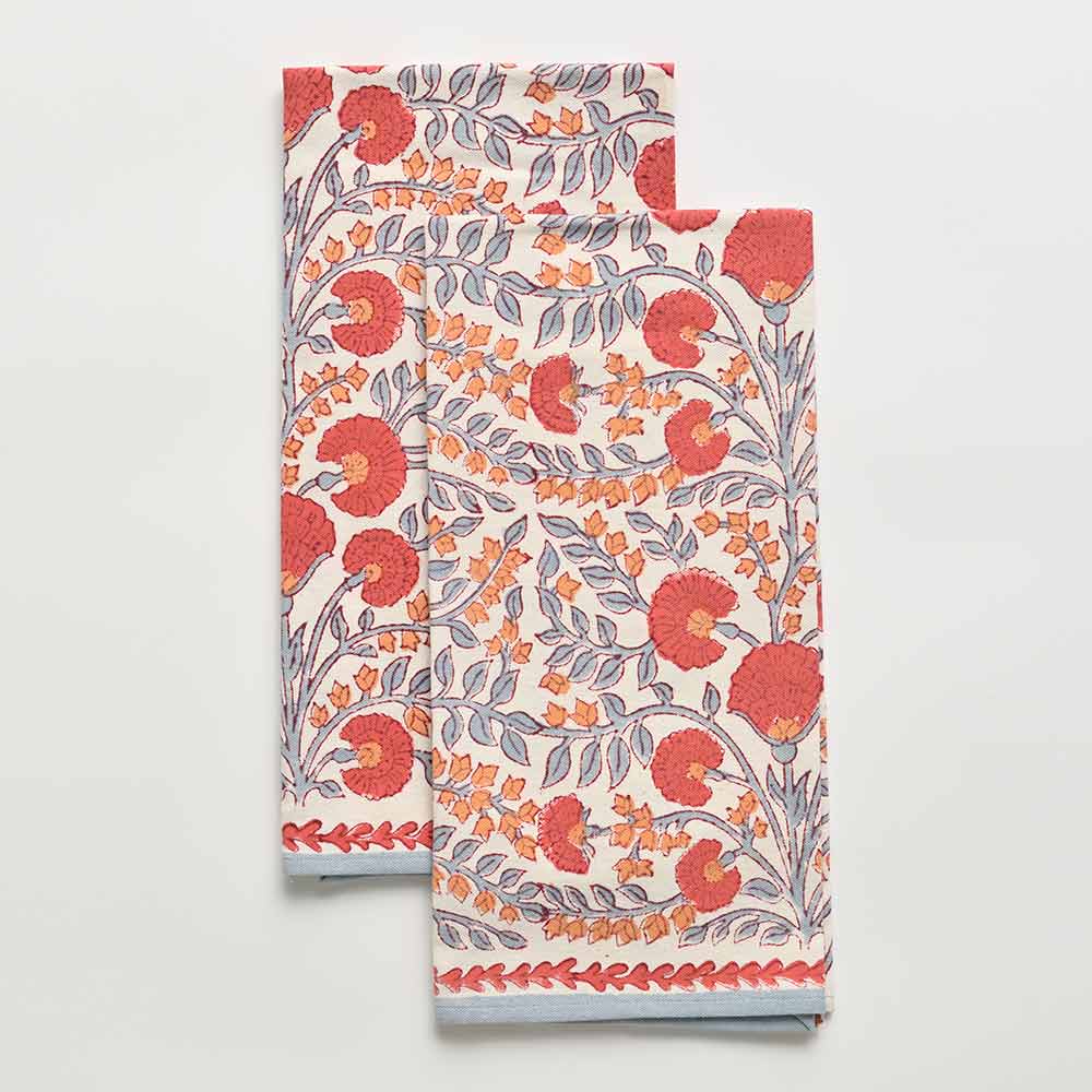 A set of two white kitchen towels with a floral pattern featuring periwinkle vines and warm orange blooms.